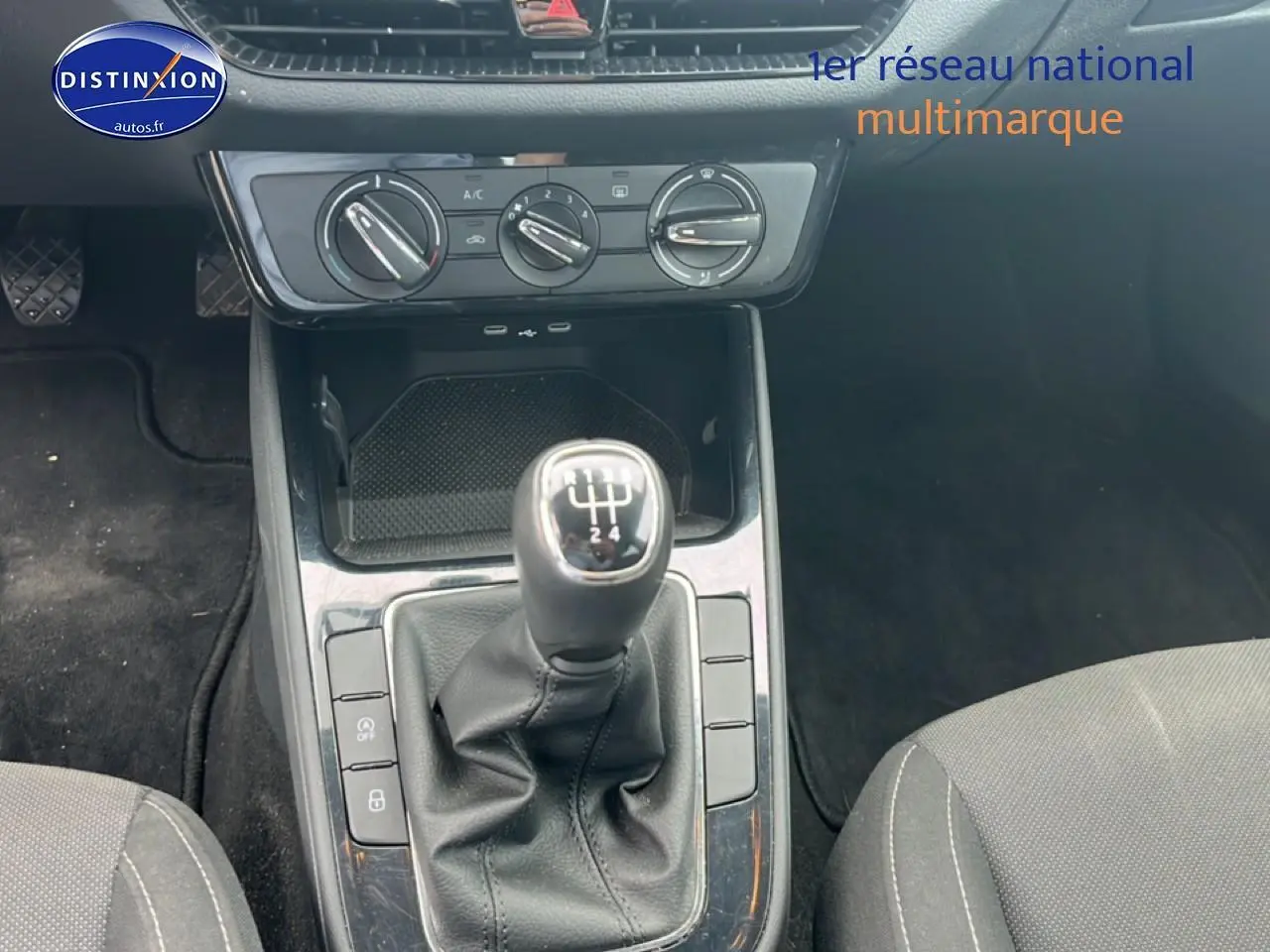 Vue intérieure centrée sur le levier de vitesse manuel et la console centrale de la Skoda Fabia bleue 2025.
