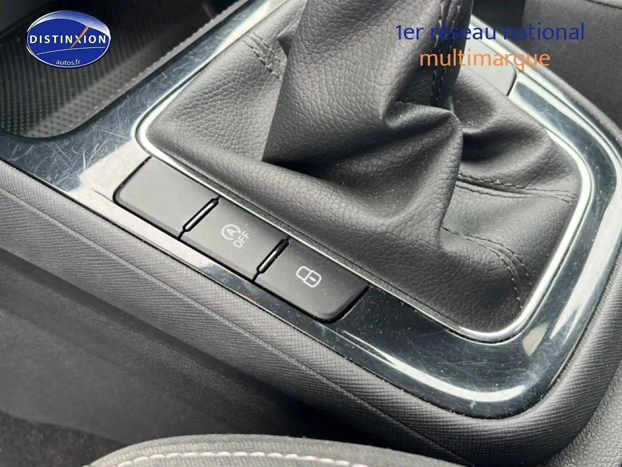Gros plan sur la console centrale noire avec levier de vitesse cuir et boutons de verrouillage et arrêt auto start d'une Skoda Fabia bleue 2025.