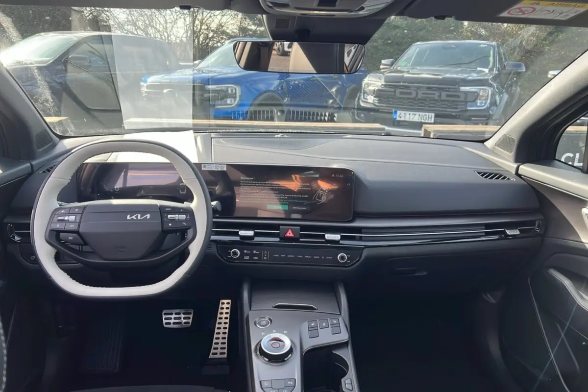 Vue intérieure avant du Kia Sportage 2026, tableau de bord noir avec écran large et volant multifonctions cuir bicolore.