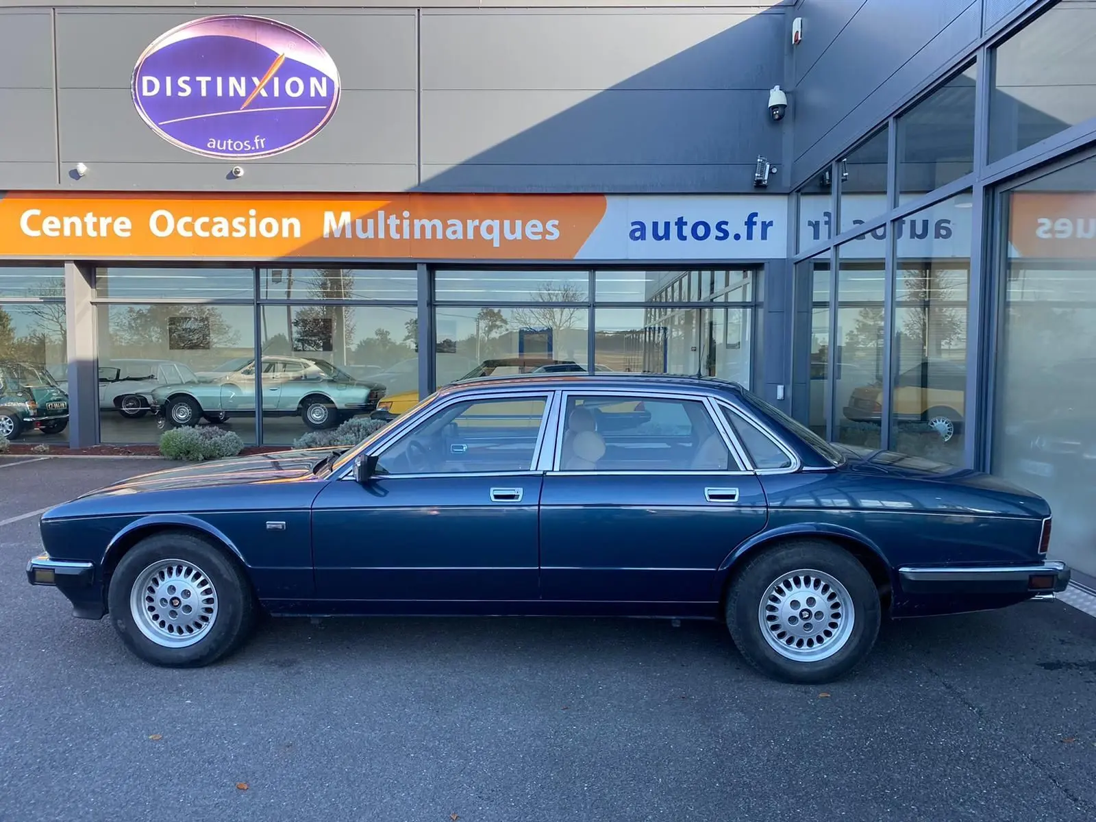 Profil côté gauche d'une Jaguar XJ6 3.6 Sovereign bleu foncé de 1987, berline classique aux jantes alliage d'origine.