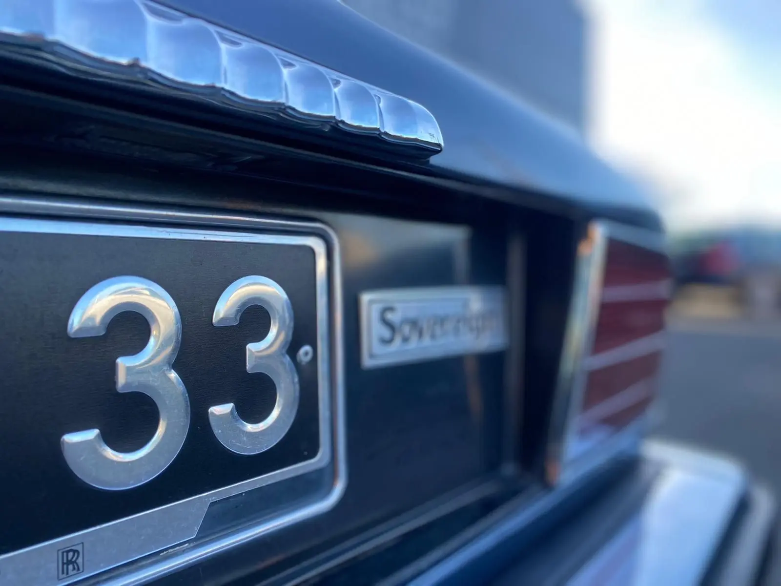 Gros plan sur l'arrière bleu d'une Jaguar XJ6 3.6 Sovereign de 1987, avec plaque et logo distinctifs visibles.