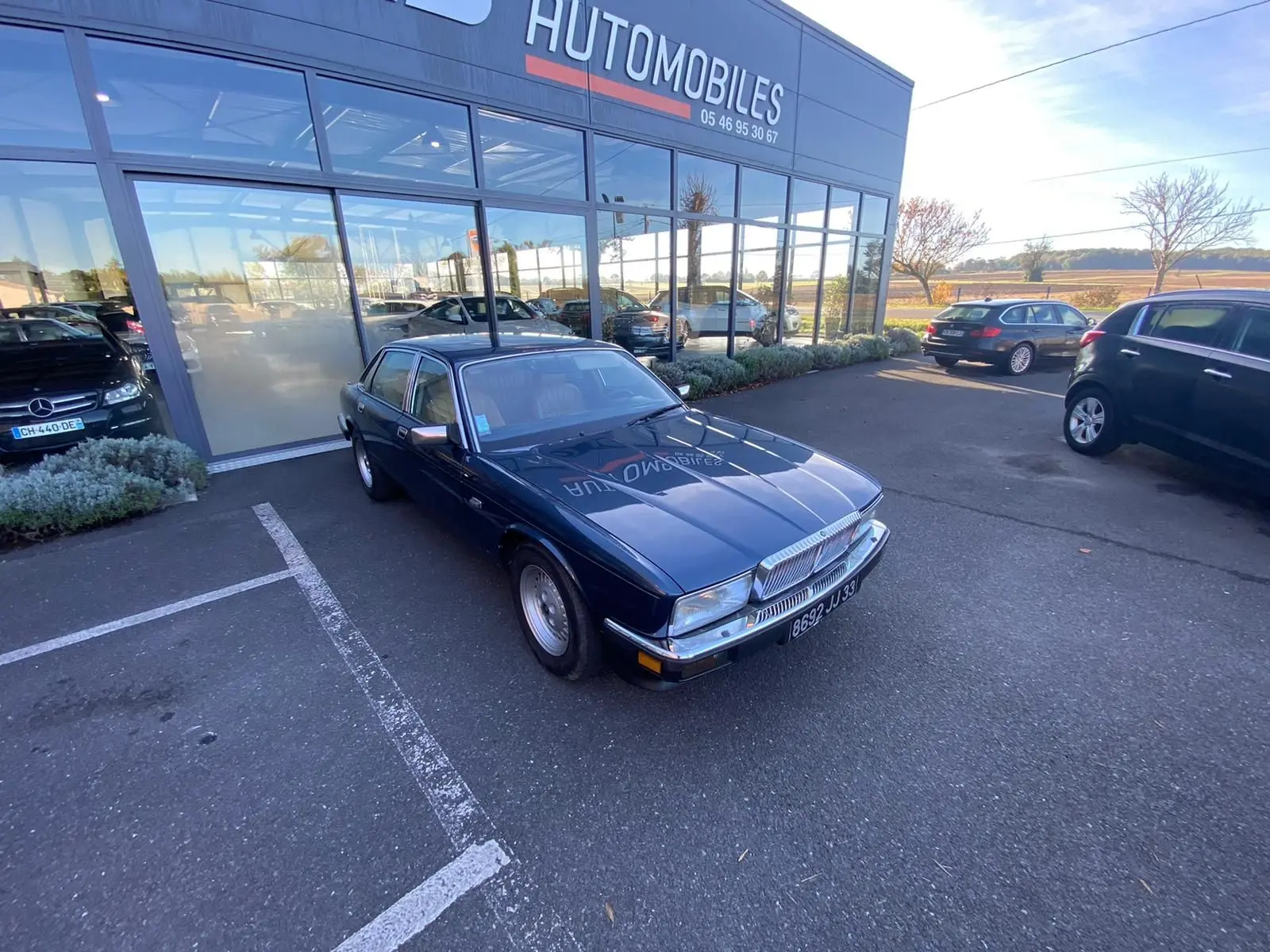 Jaguar XJ6 3.6 Sovereign bleu 1987 vue 3/4 avant droit, avec calandre chromée et jantes d'origine.