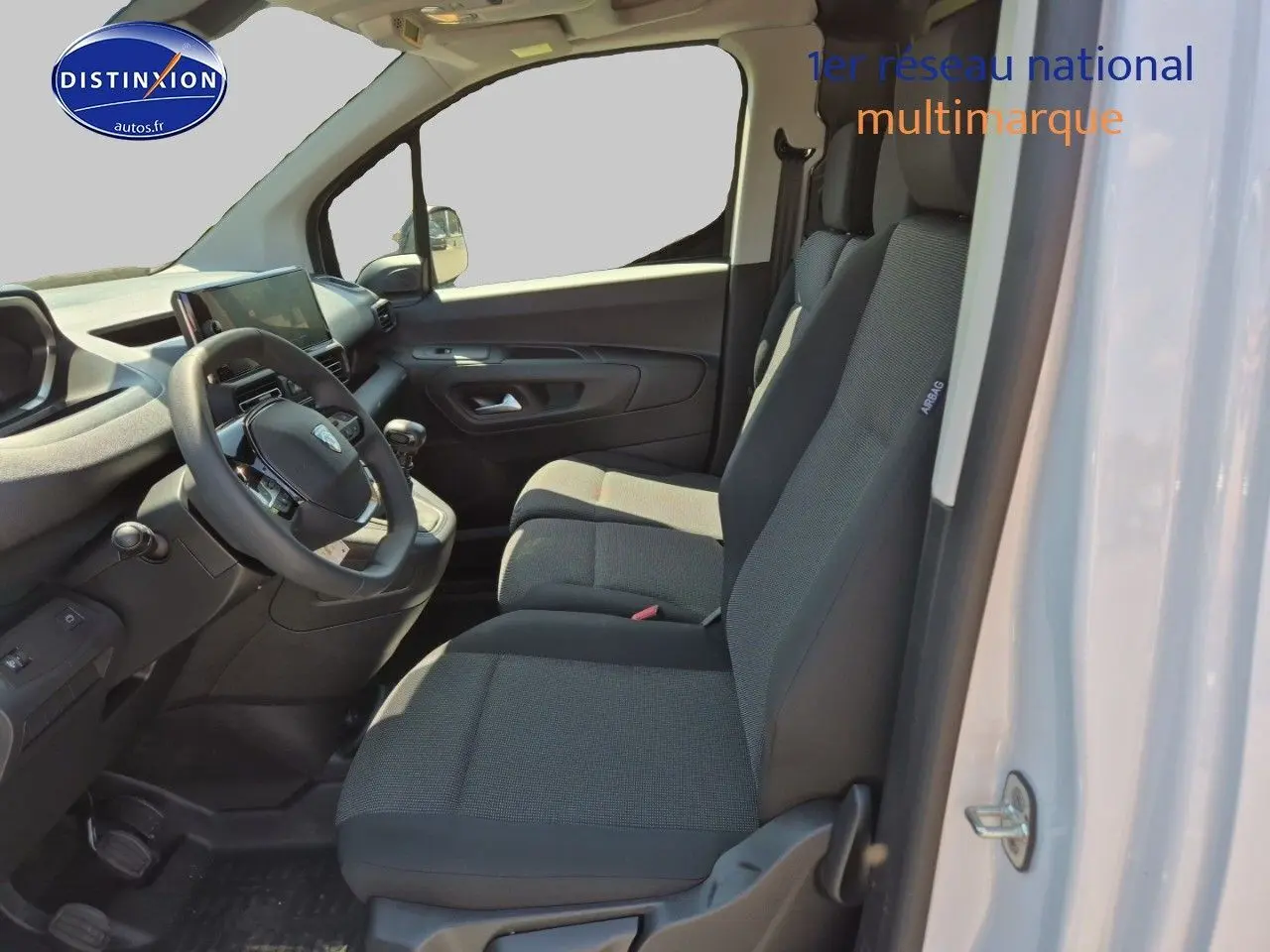 Intérieur du Peugeot Partner 2025 vu côté droit, montrant les sièges gris et le tableau de bord noir.