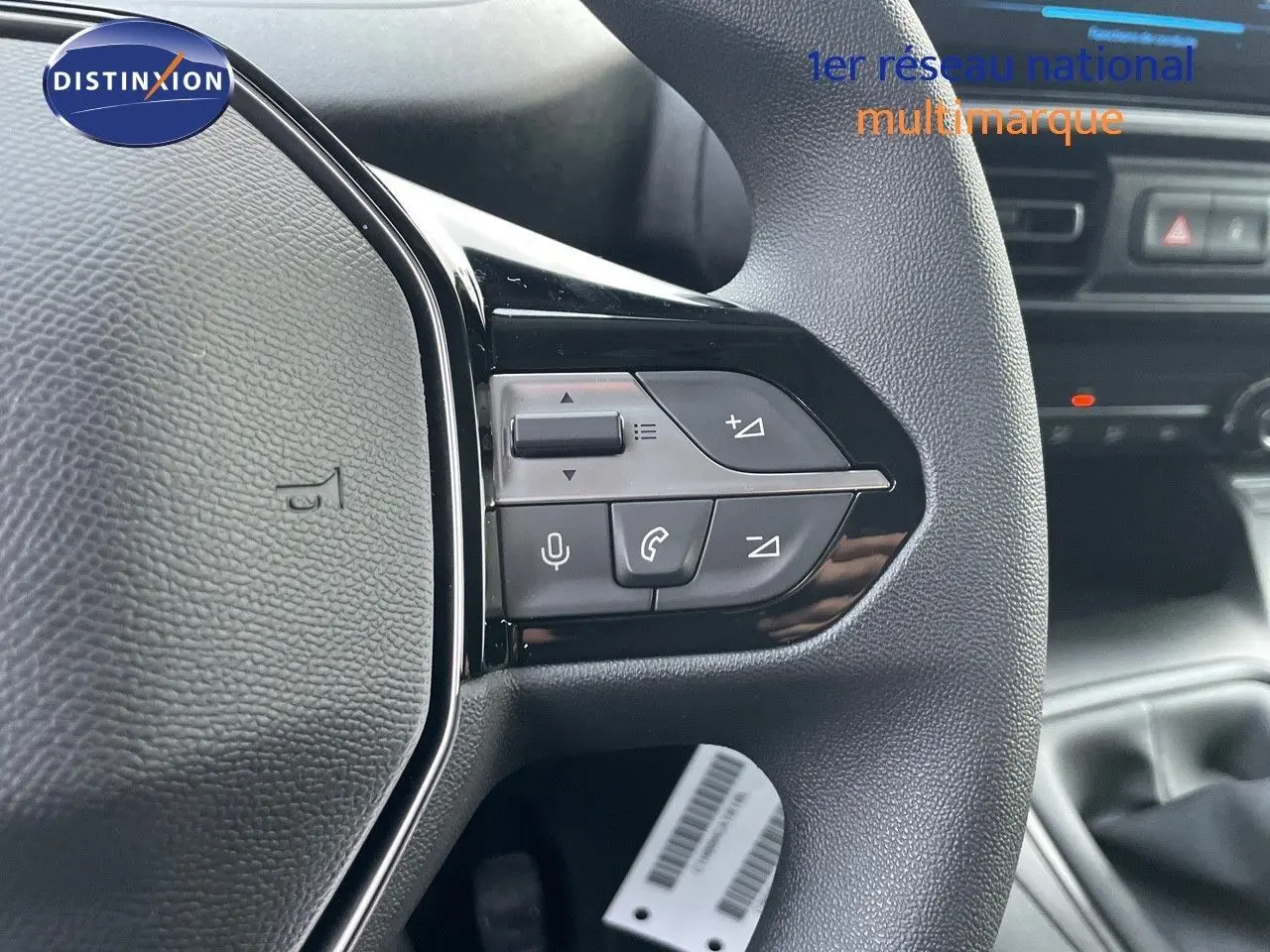Gros plan sur le volant côté gauche du Peugeot Partner 2025, avec commandes audio et téléphone intégrées.