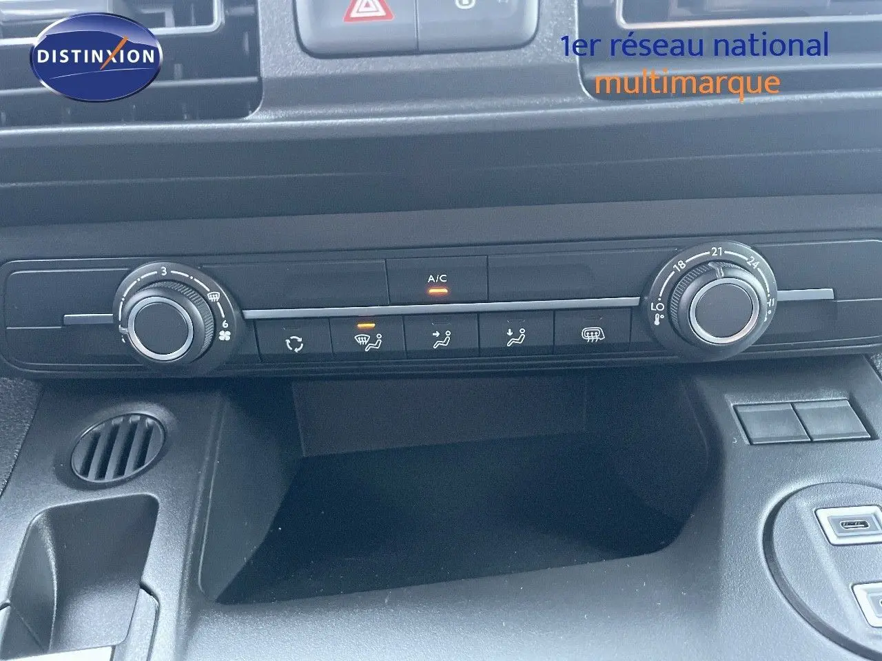 Vue rapprochée de la console centrale noire du Peugeot Partner 2025, avec commandes de climatisation et ventilation.