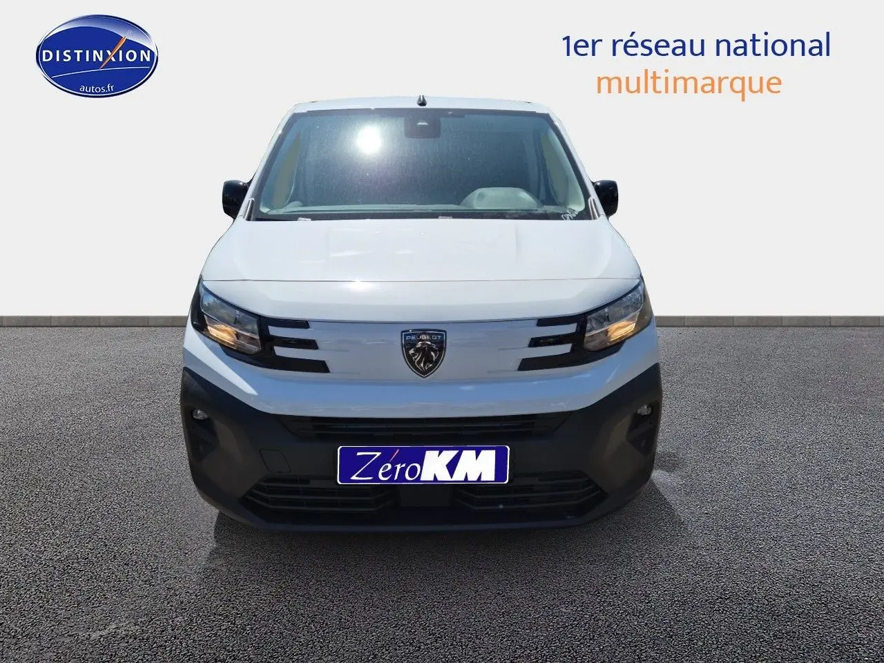 Vue frontale d'un Peugeot Partner blanc 2025 avec calandre noire et logo lion central bien visible.