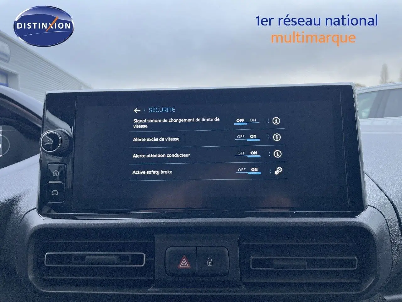 Vue intérieure du tableau de bord du Peugeot Partner 2025, écran tactile affichant les options de sécurité, ambiance sobre et moderne.