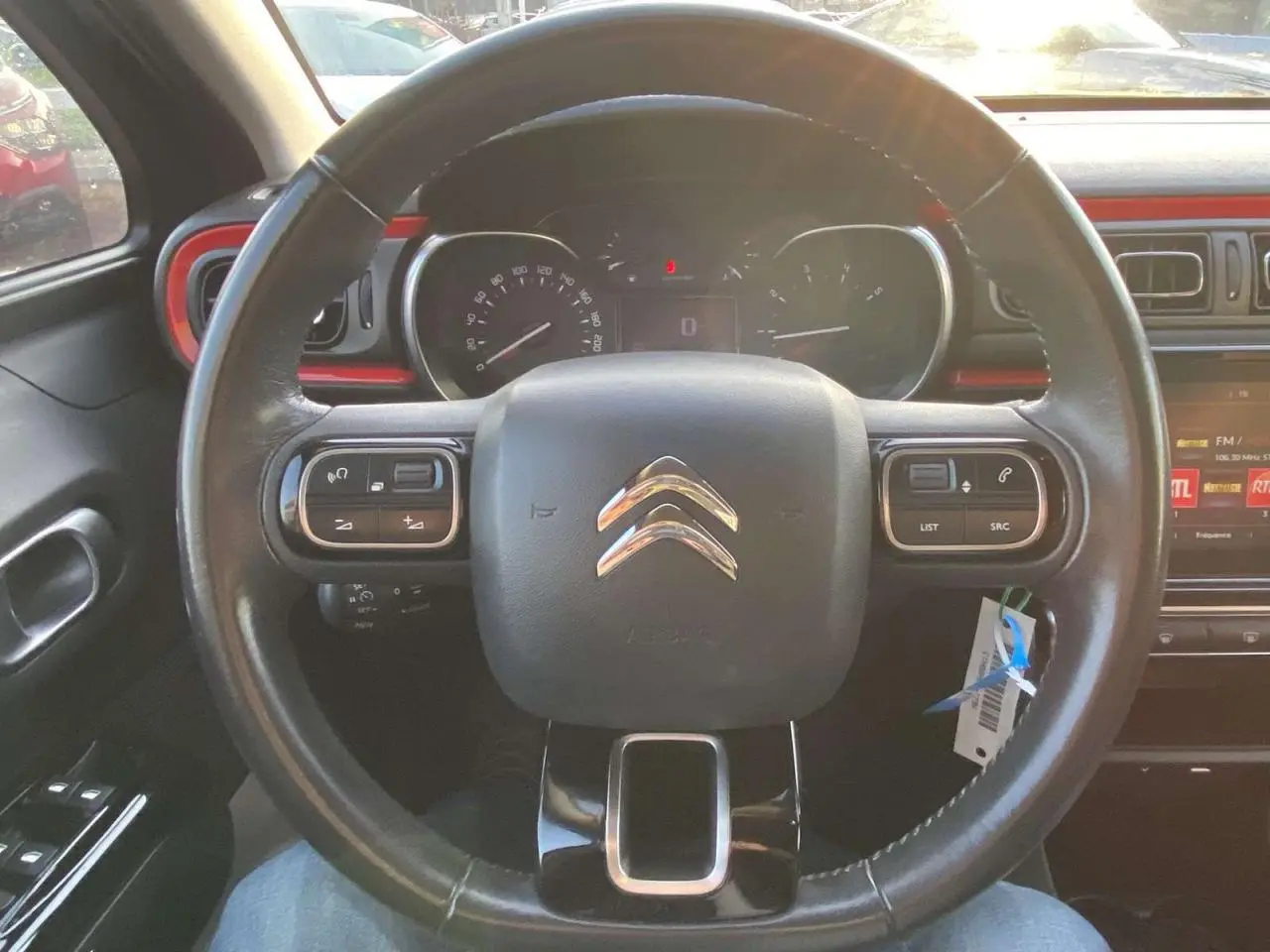 Vue rapprochée du volant noir de la Citroën C3 2017 avec tableau de bord et touches de commande intégrées.