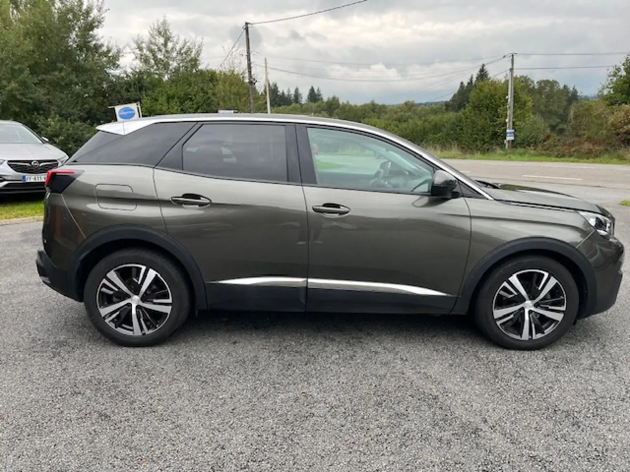 Profil côté droit du Peugeot 3008 gris Amazonite 2019 avec jantes alliage et toit noir contrasté.
