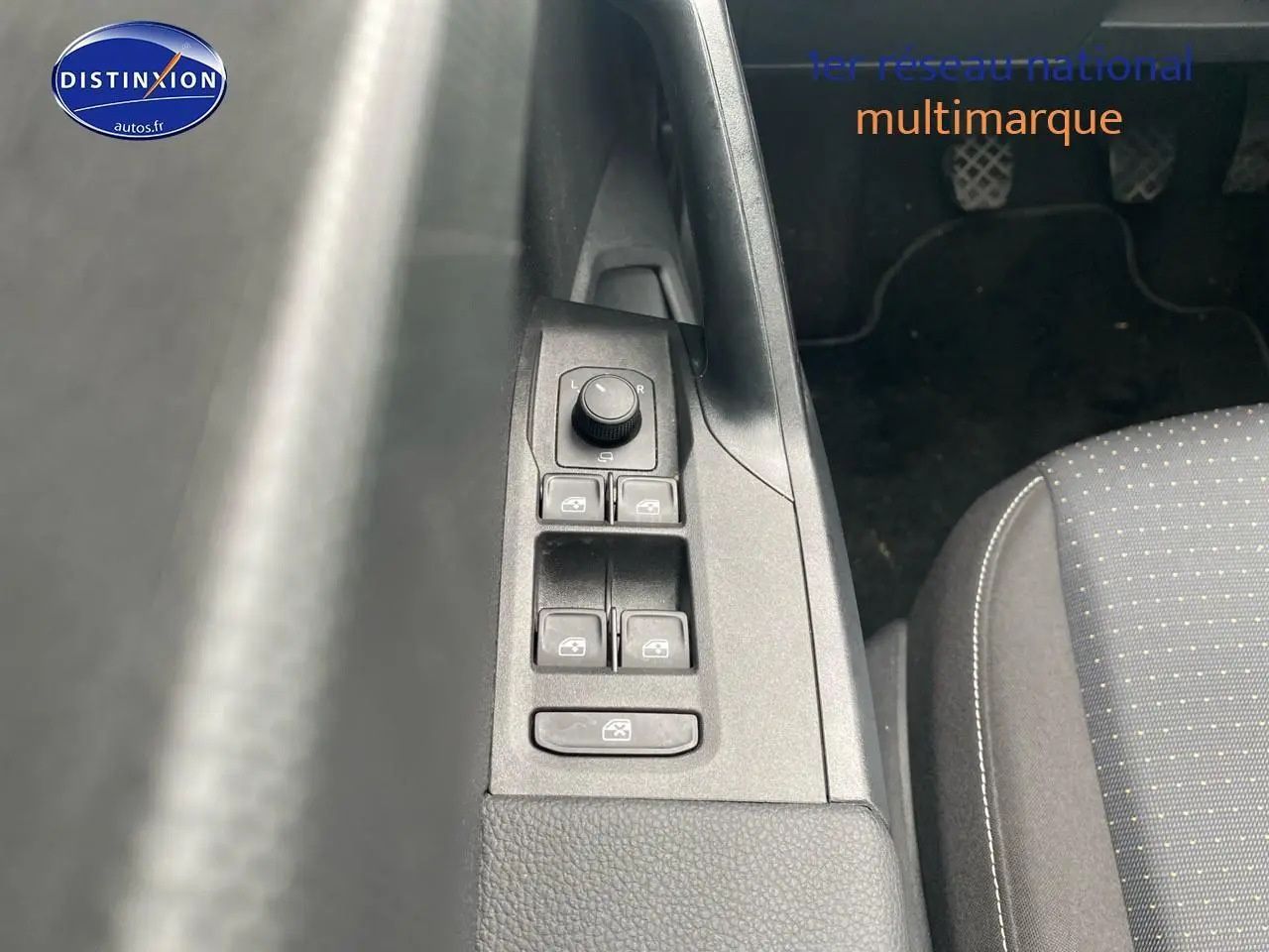 Vue rapprochée sur la commande des vitres électriques côté conducteur et tissu gris du siège d’une SEAT Ibiza noir minuit 2025.