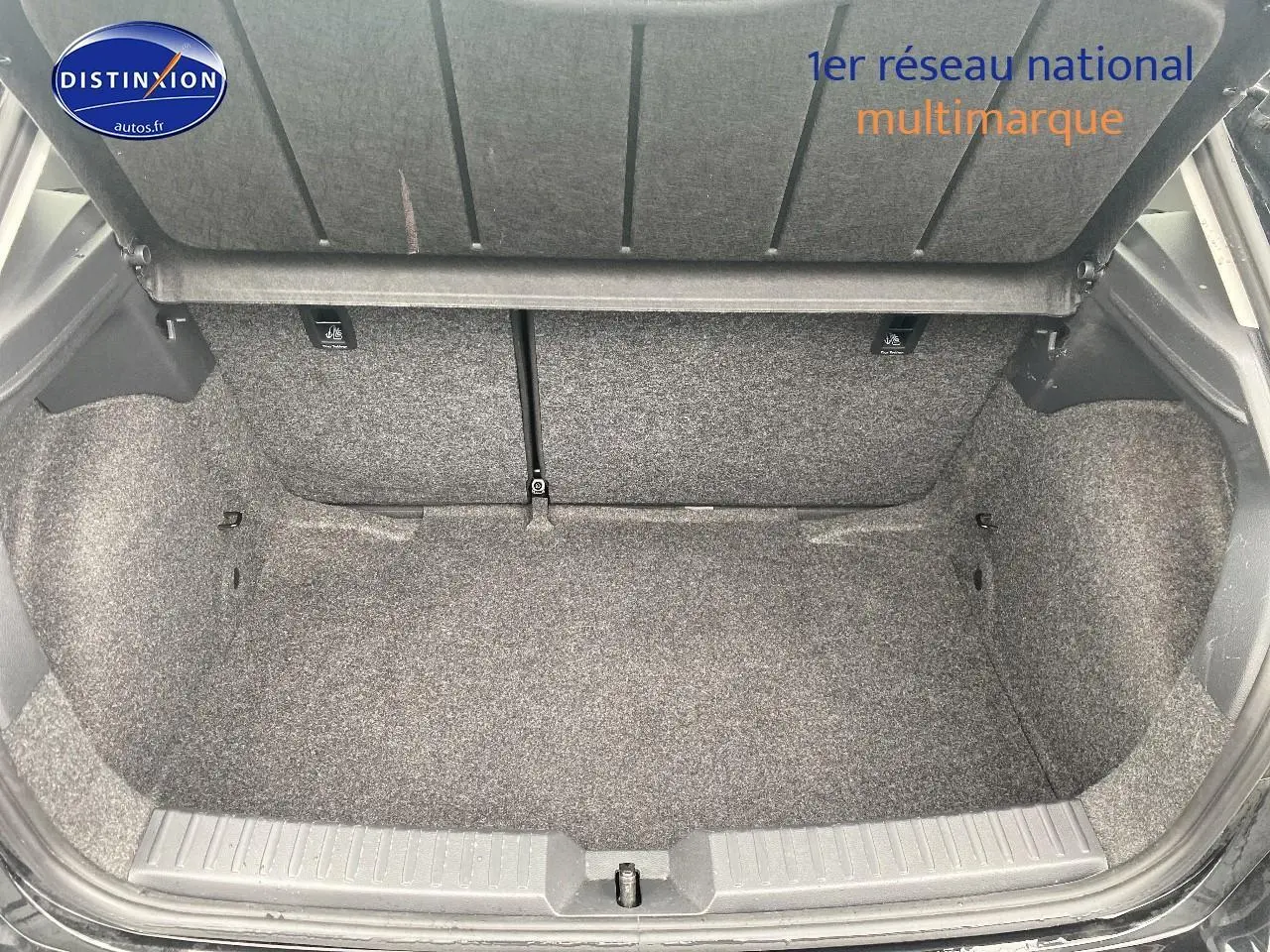 Coffre ouvert vu de l'arrière d'une SEAT Ibiza noir minuit, montrant l'espace de chargement et la moquette grise.