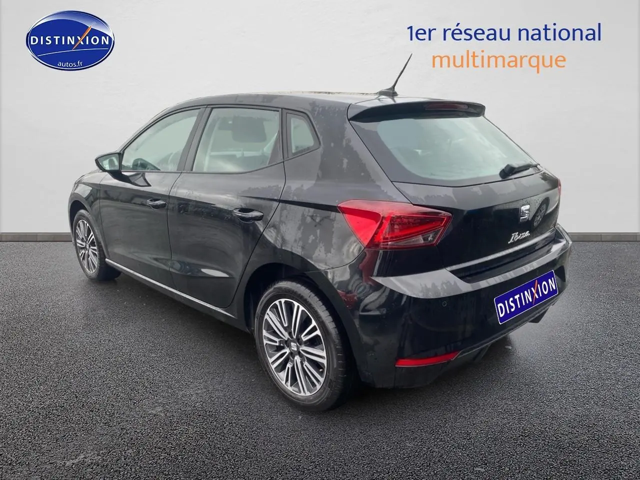 Vue 3/4 arrière droite d'une SEAT Ibiza noir minuit avec jantes alliage et signature Ibiza manuscrite sur hayon.