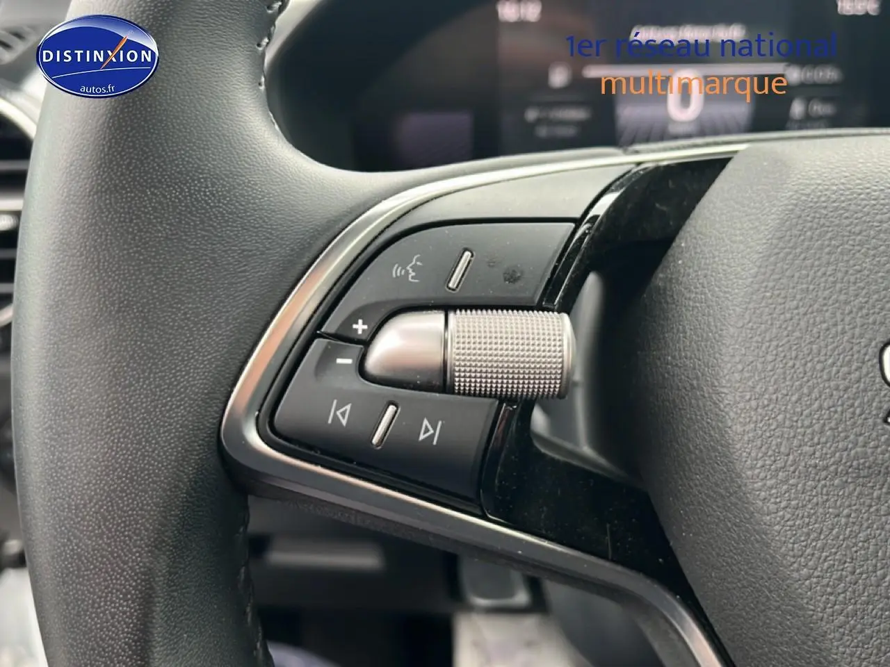Gros plan sur les commandes audio au volant cuir noir d'une Skoda Fabia blanche, version 2025, essence.