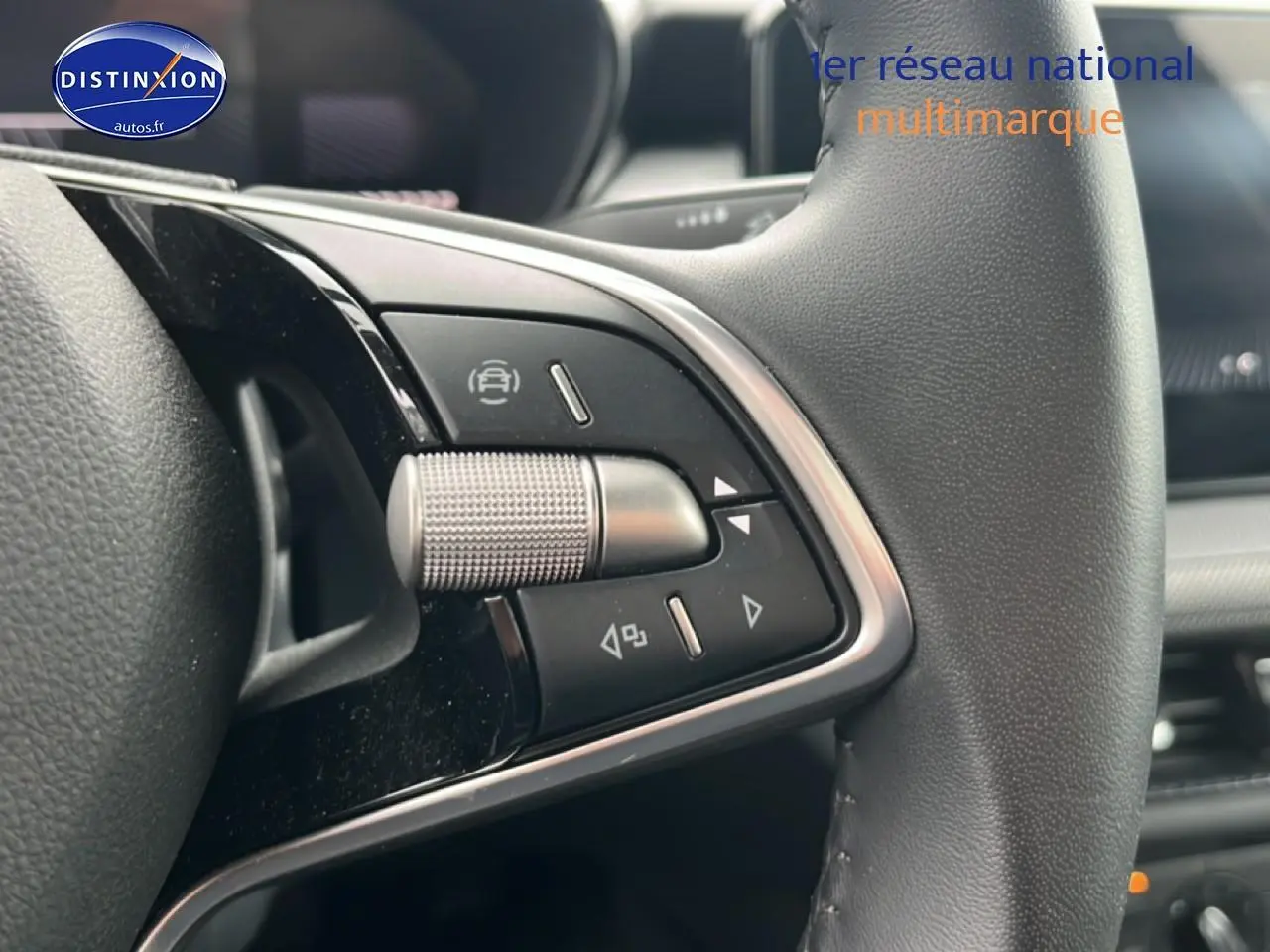 Gros plan sur les commandes multifonctions en métal et cuir du volant d’une Skoda Fabia blanche, version 2025.