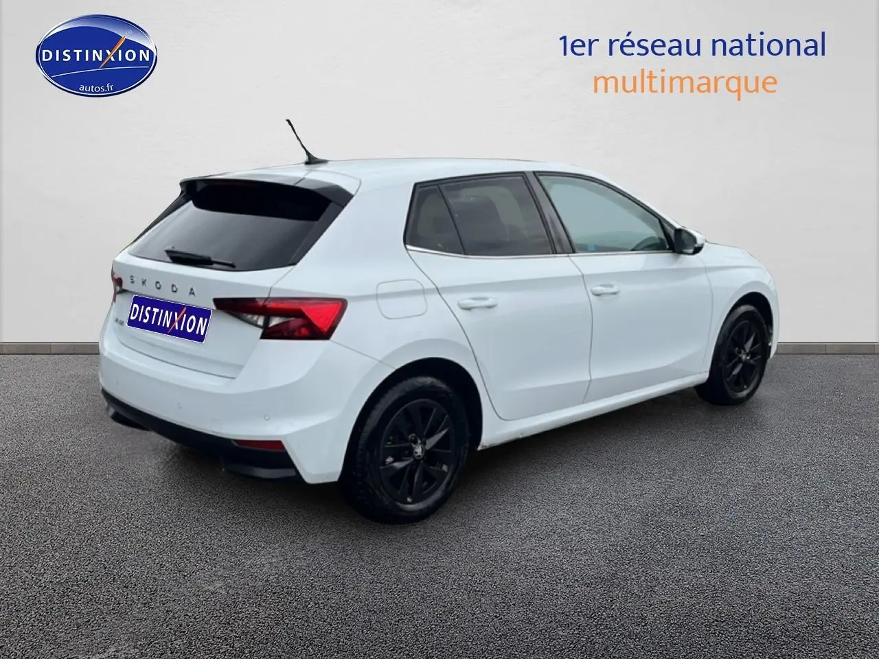 Vue 3/4 arrière droite d'une Skoda Fabia blanche 2025 avec jantes noires et vitres arrière teintées.