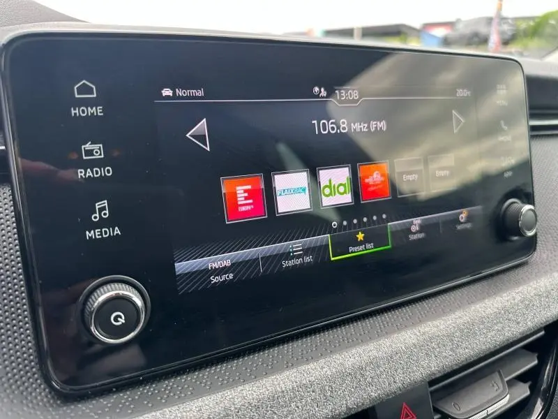 Écran tactile multimédia de la Skoda Scala 2025 affichant les stations radio FM/DAB en intérieur noir.