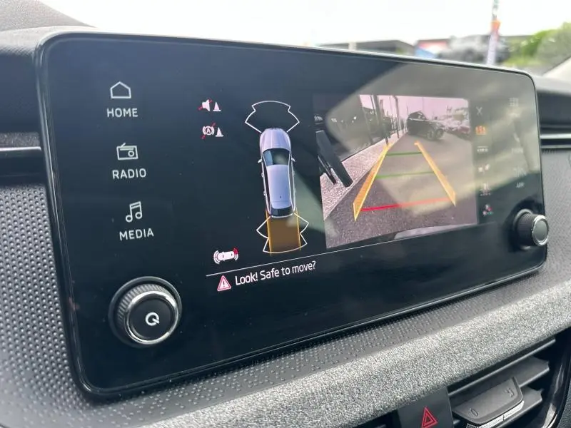Écran tactile intérieur de la Skoda Scala blanc montrant la caméra de recul avec aides au stationnement.