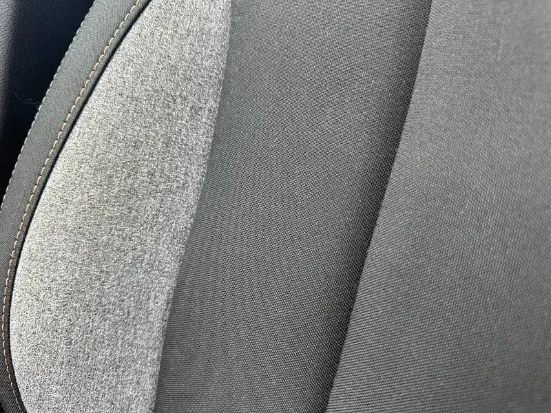 Gros plan sur le tissu noir et gris recyclé du siège avant de la Skoda Scala 2025, avec surpiqûres contrastantes.