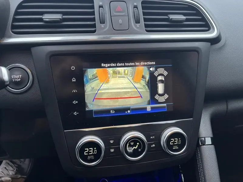 Tableau de bord du Renault Kadjar blanc 2022 avec écran tactile affichant la caméra de recul et commandes climatisation.
