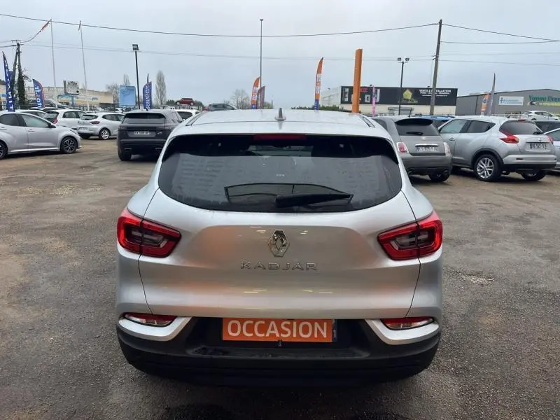 Vue arrière d'un Renault Kadjar blanc Glacier avec feux LED et plaque "OCCASION" sur un parking extérieur.