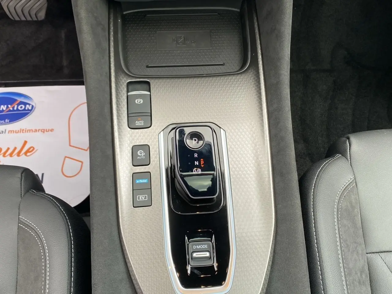 Vue plongeante sur la console centrale gris céramique du Nissan Qashqai 2025 avec levier de vitesses et boutons de contrôle.