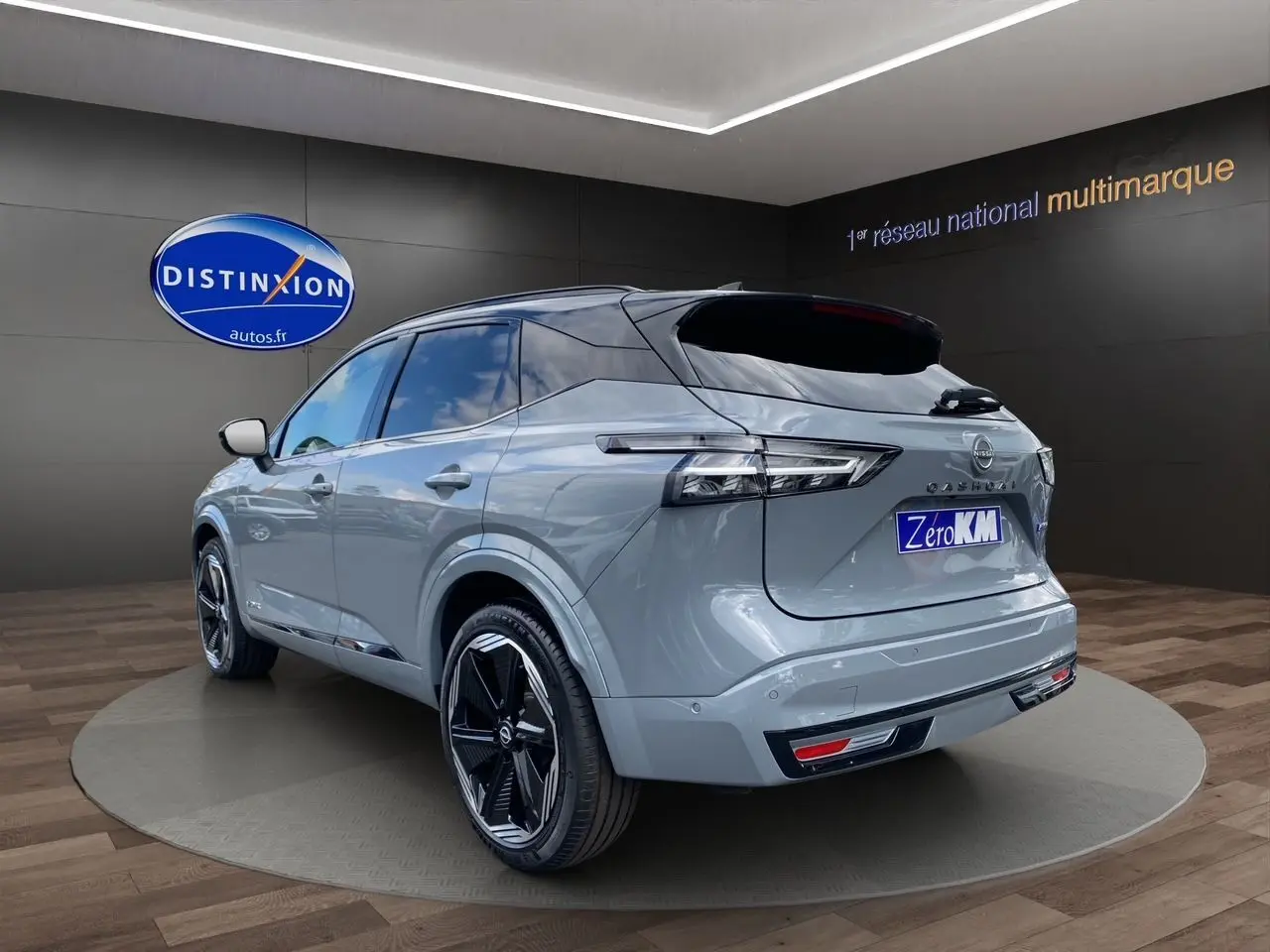 Vue 3/4 arrière droite du Nissan Qashqai 2025 gris ceramic et noir avec jantes noires distinctives en showroom