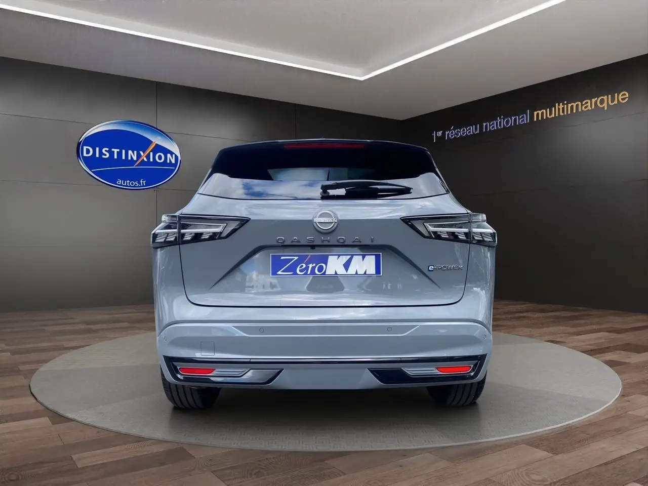 Vue arrière du Nissan Qashqai 1.5 e-POWER 190 BVA N-DESIGN en gris ceramic avec toit noir dans un showroom.
