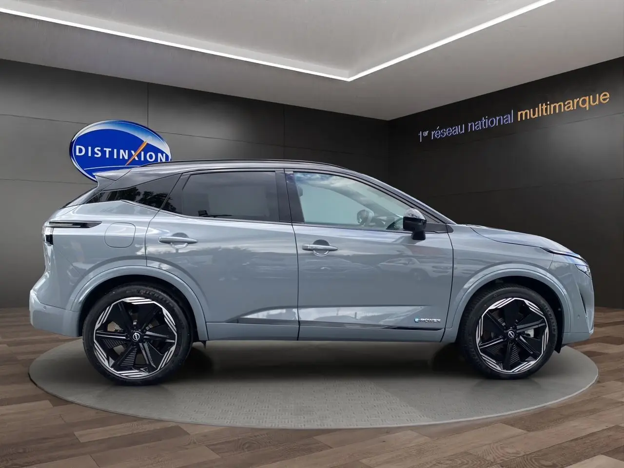 Vue latérale droite du Nissan Qashqai 2025 gris céramic avec toit noir et jantes noires distinctives.