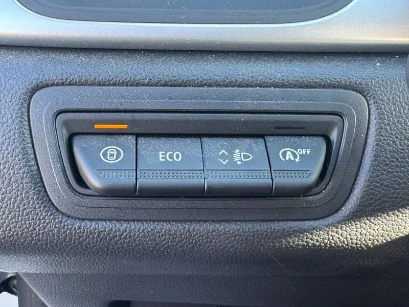 Gros plan sur les boutons de commande du tableau de bord du Renault Captur noir 2025, mode ECO et verrouillage visibles.