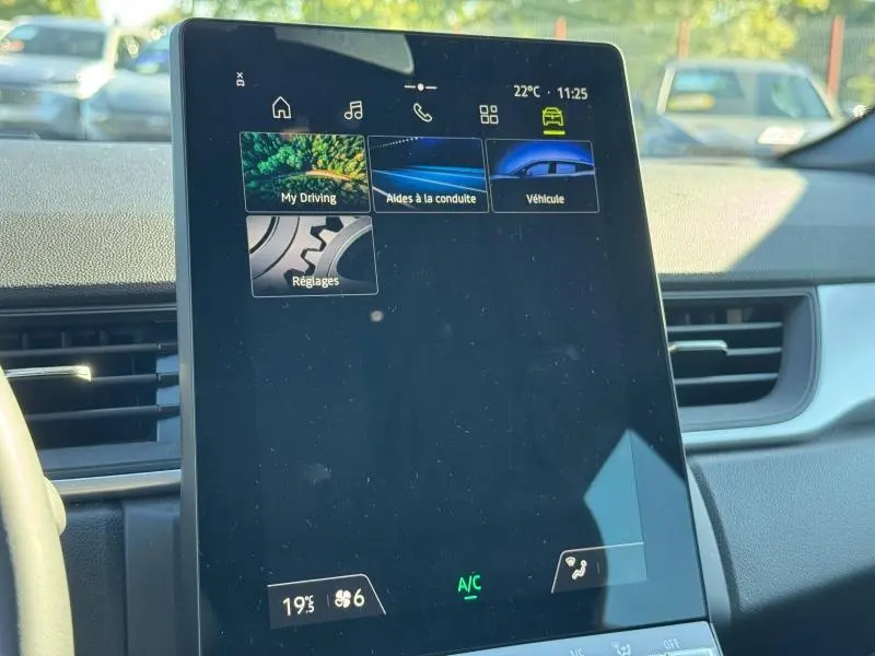 Écran tactile central du tableau de bord du Renault Captur noir 2025, affichant les menus d'aide à la conduite et réglages.