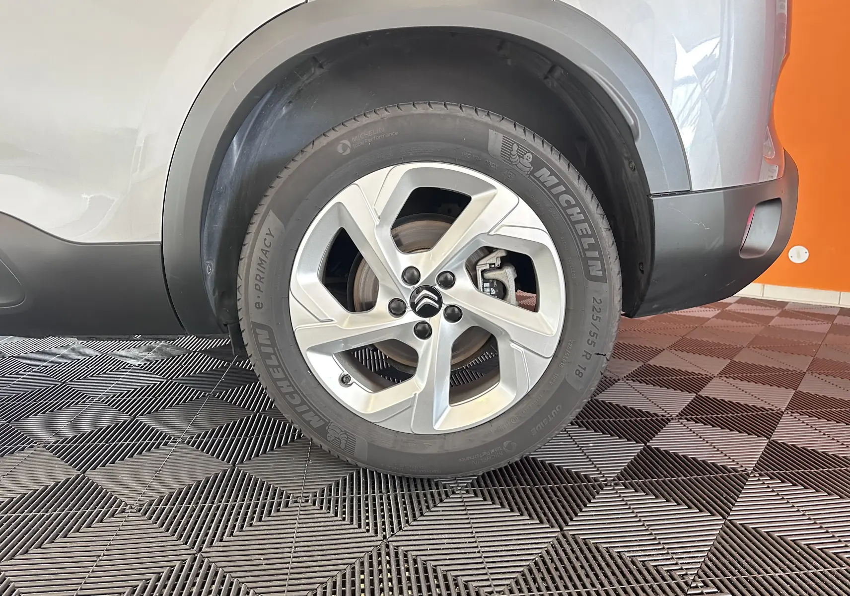 Gros plan sur la roue arrière droite d'un Citroën C5 Aircross gris Artense avec jante alliage 18 pouces et pneu Michelin.