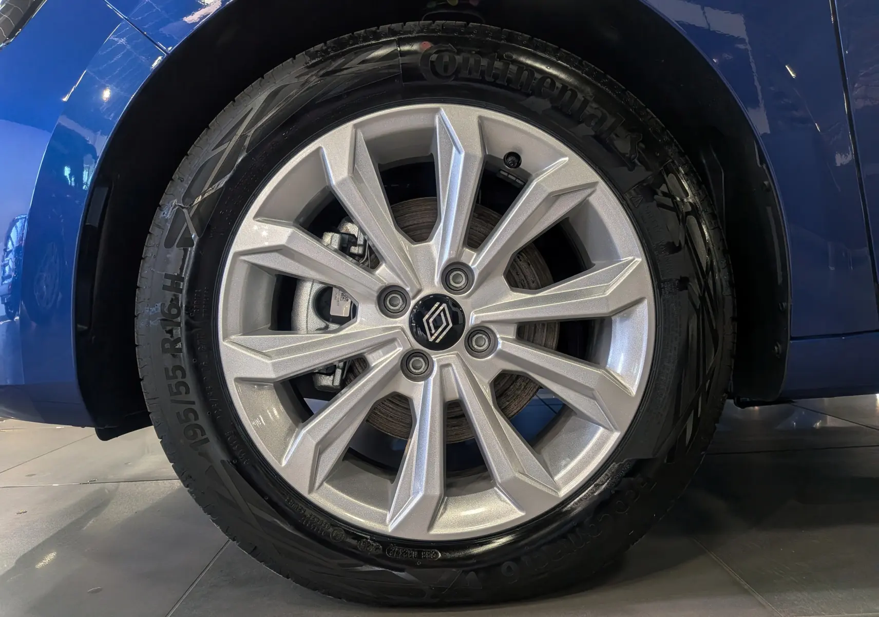 Gros plan sur la roue avant gauche de la Renault Clio V Bleu Iron, mettant en valeur la jante alliage argentée au design moderne.