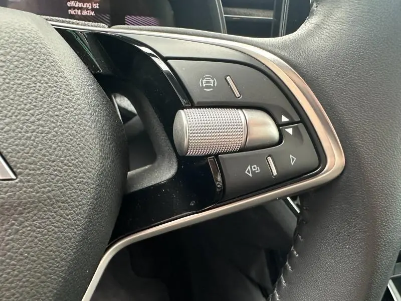 Gros plan sur les commandes multifonctions côté gauche du volant cuir noir de la Skoda Scala 2025 finition Selection.