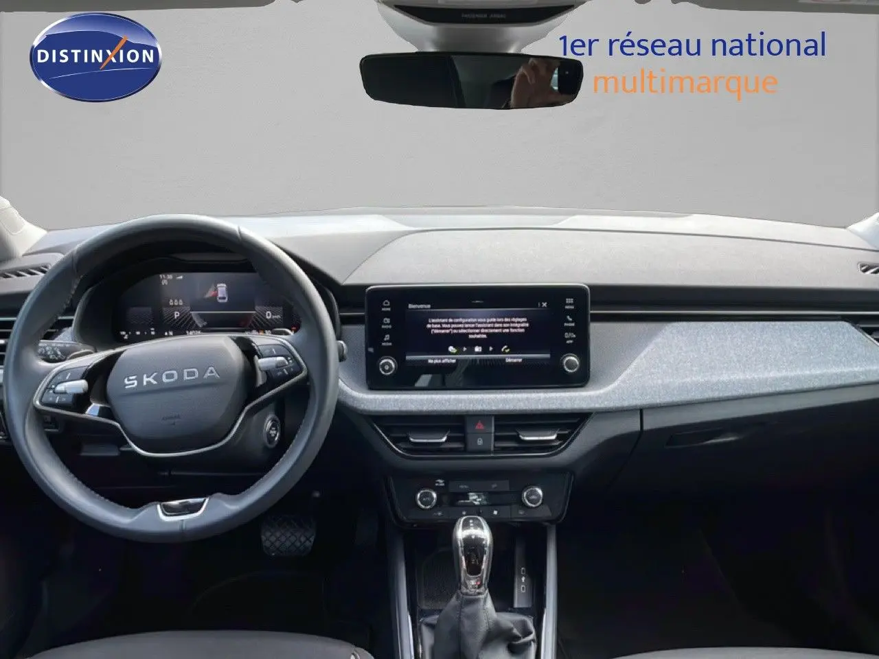 Vue intérieure frontale du tableau de bord gris noir et volant cuir multifonction de la Skoda Scala 2025 blanc glacier.