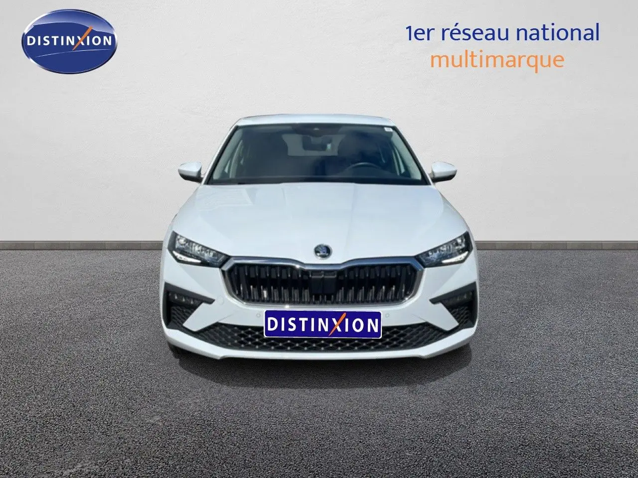 Vue frontale d'une Skoda Scala blanc glacier avec calandre noire et phares LED distinctifs.