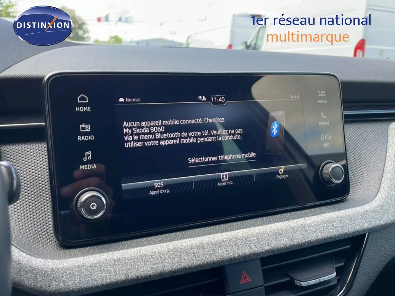 Écran tactile central de la Skoda Scala blanc glacier, vue rapprochée du tableau de bord avec interface connectée.