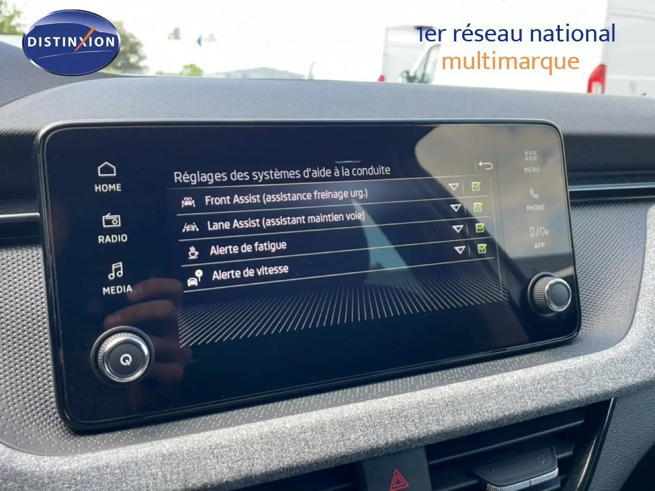 Écran tactile central affichant les réglages d’aide à la conduite dans une Skoda Scala blanche Glacier, vue intérieure.