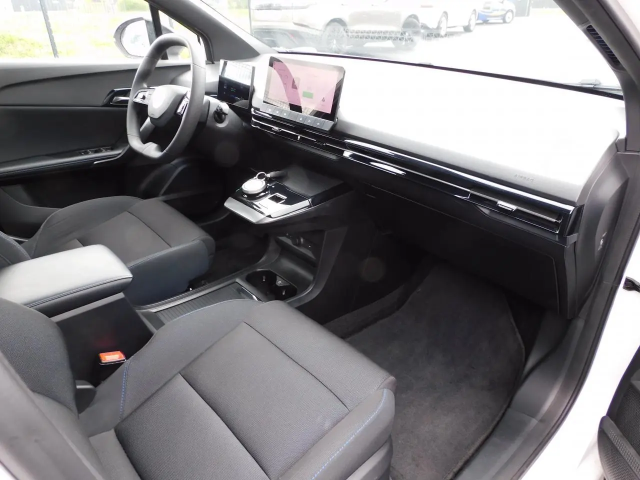 Intérieur avant du MG4 blanc 2023, vue côté passager mettant en valeur le tableau de bord épuré et l'écran tactile central.