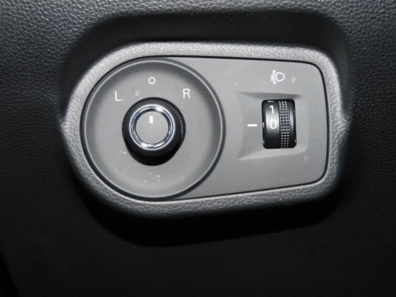 Gros plan sur les commandes de réglage des rétroviseurs et de l'éclairage du tableau de bord du MG MOTOR MG4 blanc 2023.