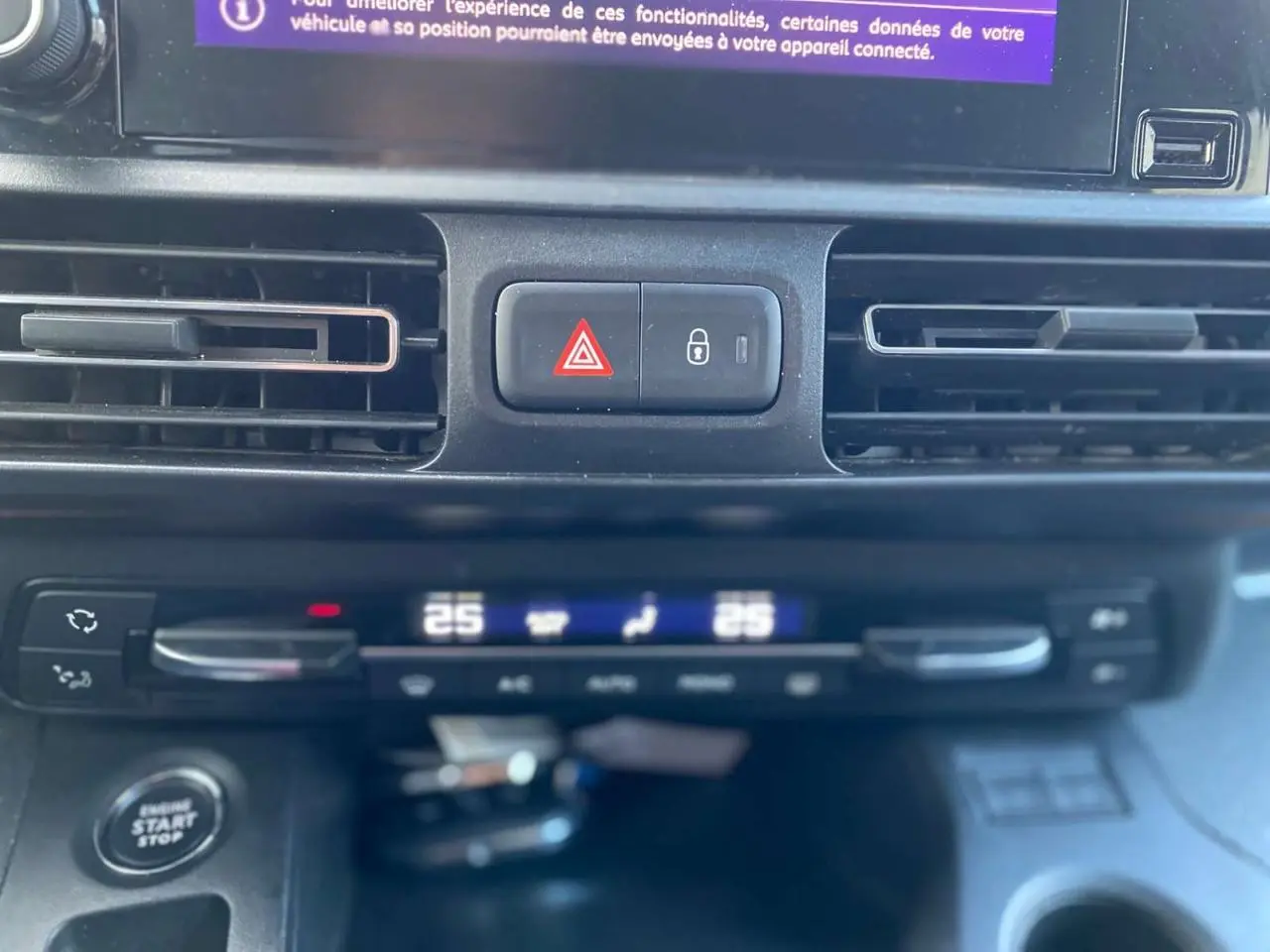 Détail du tableau de bord du Peugeot Rifter GT 2023 montrant la climatisation automatique bi-zone et les boutons de sécurité.