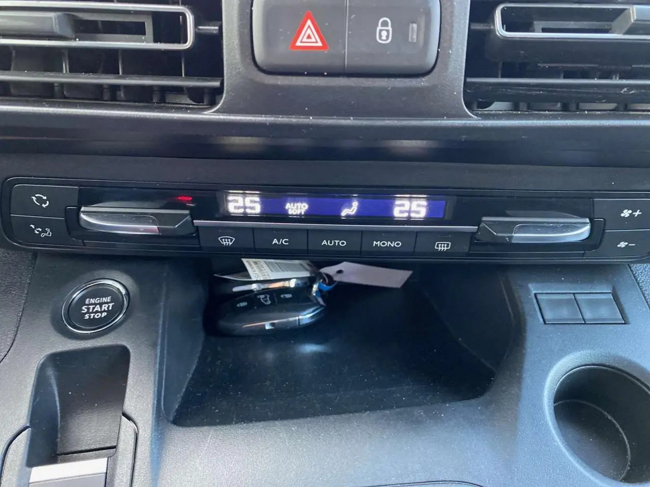 Tableau de bord du Peugeot Rifter GT 2023, vue rapprochée sur la climatisation bi-zone et bouton start/stop.