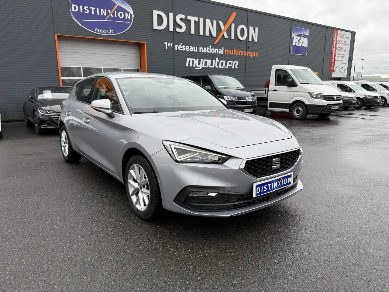 SEAT Leon 2.0 TDI 2022 argent Urban vue 3/4 avant sur parking devant concession multimarque