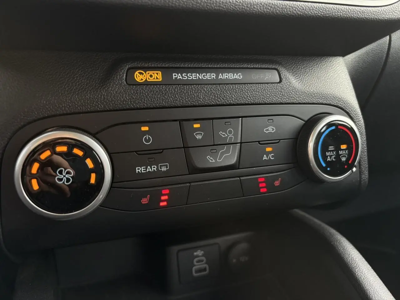 Gros plan sur la console centrale du Ford Kuga 2024, montrant les commandes de climatisation et sièges chauffants.