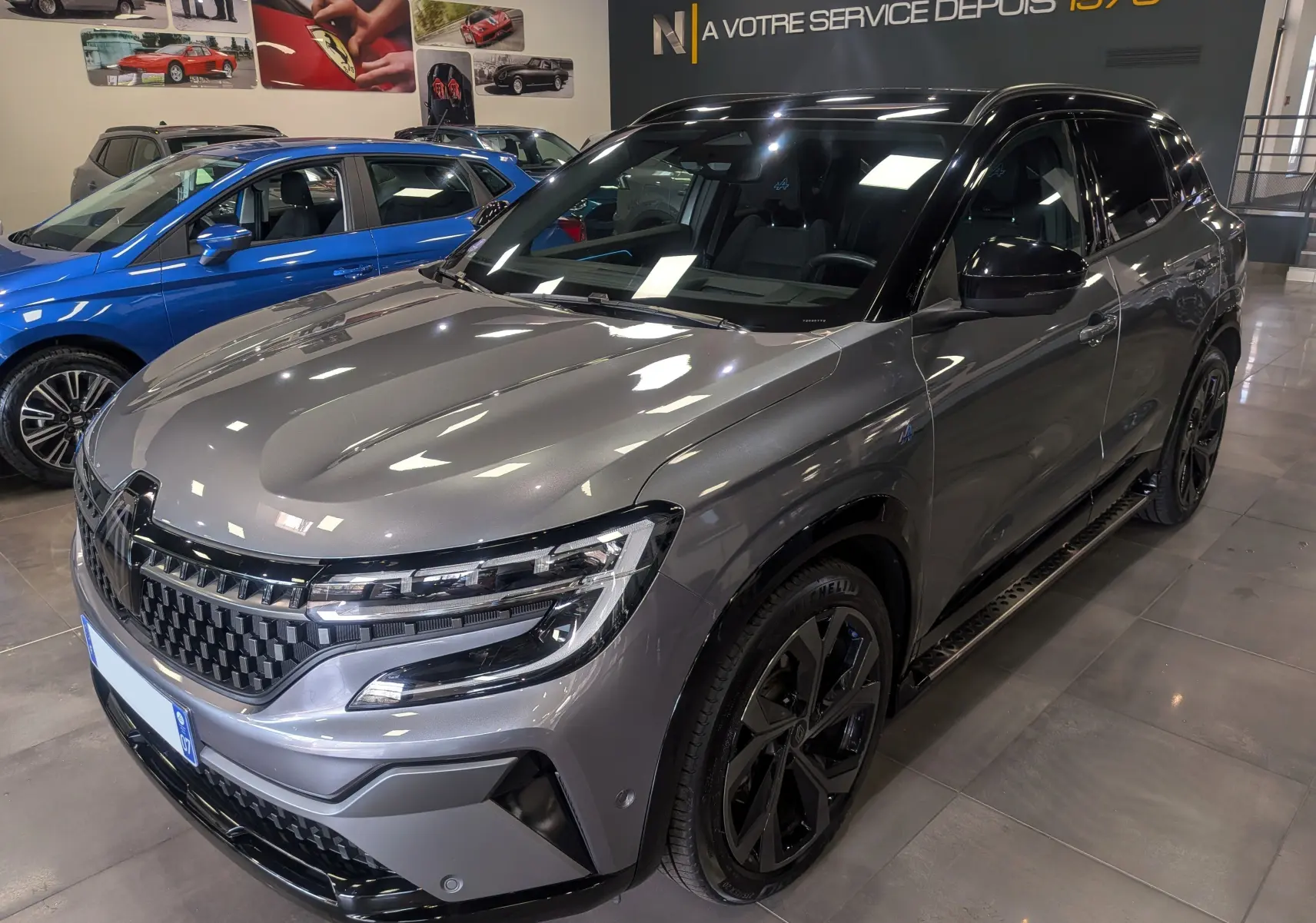 Renault Austral E-Tech hybrid 200 Iconic esprit Alpine gris schiste avec toit noir, vue 3/4 avant droit en showroom.