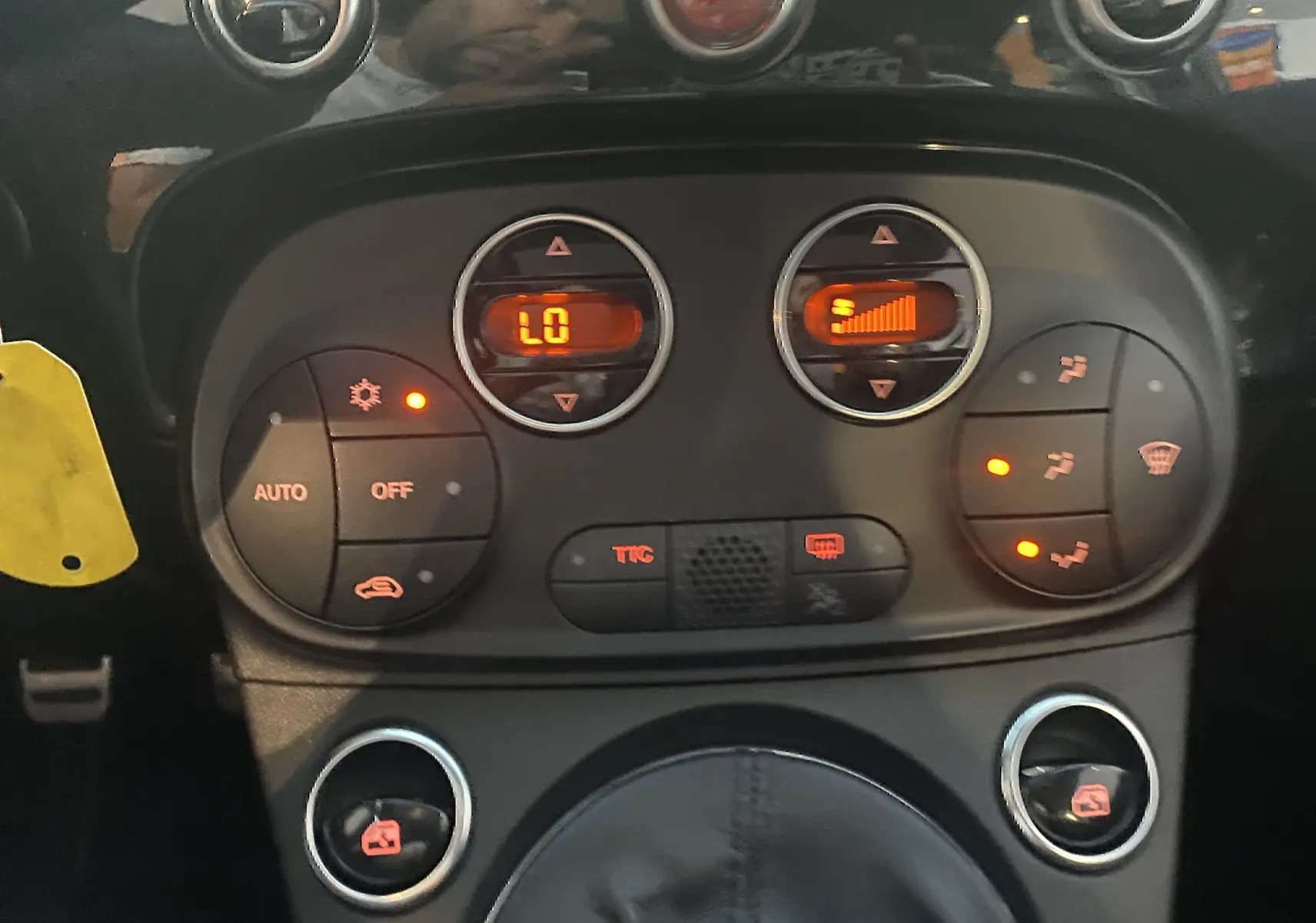 Gros plan sur la console centrale de l'Abarth 595 noire, montrant les commandes de climatisation automatique et les boutons de réglage.