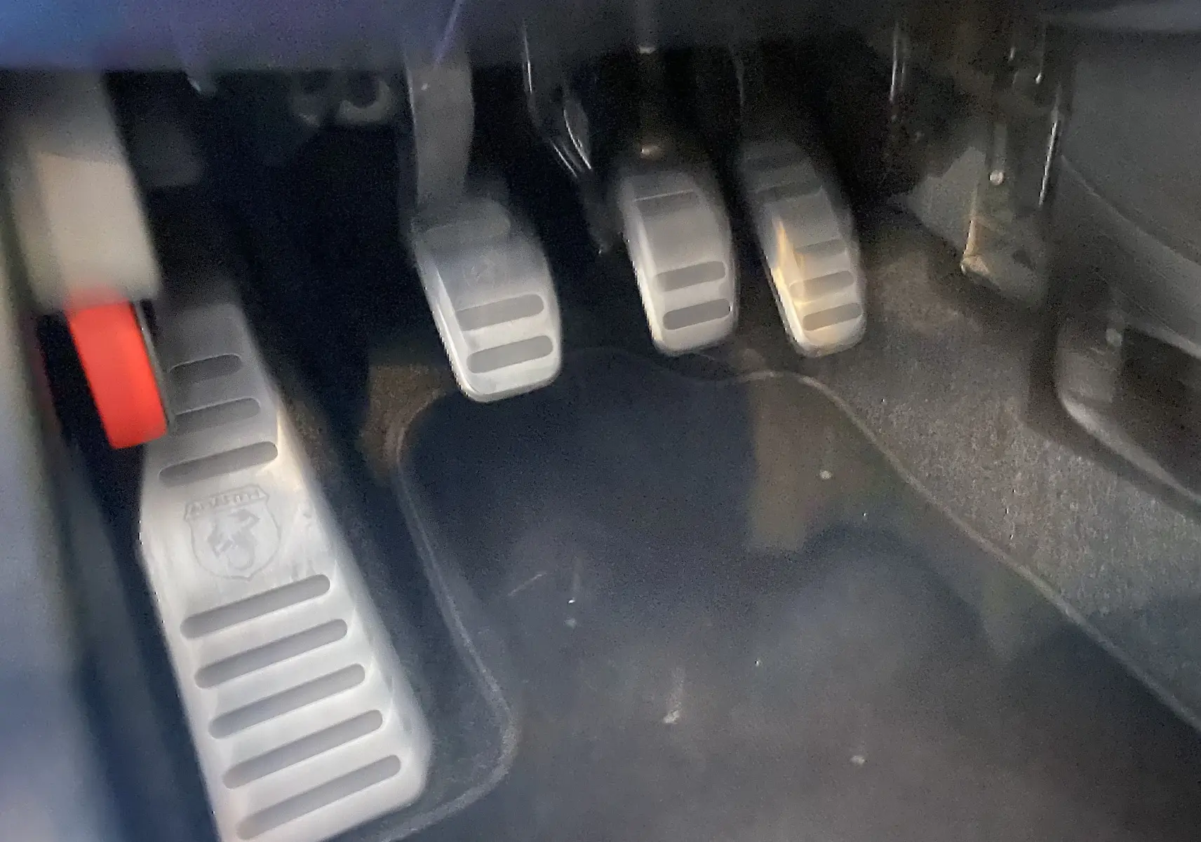 Vue rapprochée des pédales en aluminium avec logo Abarth sur le repose-pied côté gauche d'une ABARTH 595 noire.