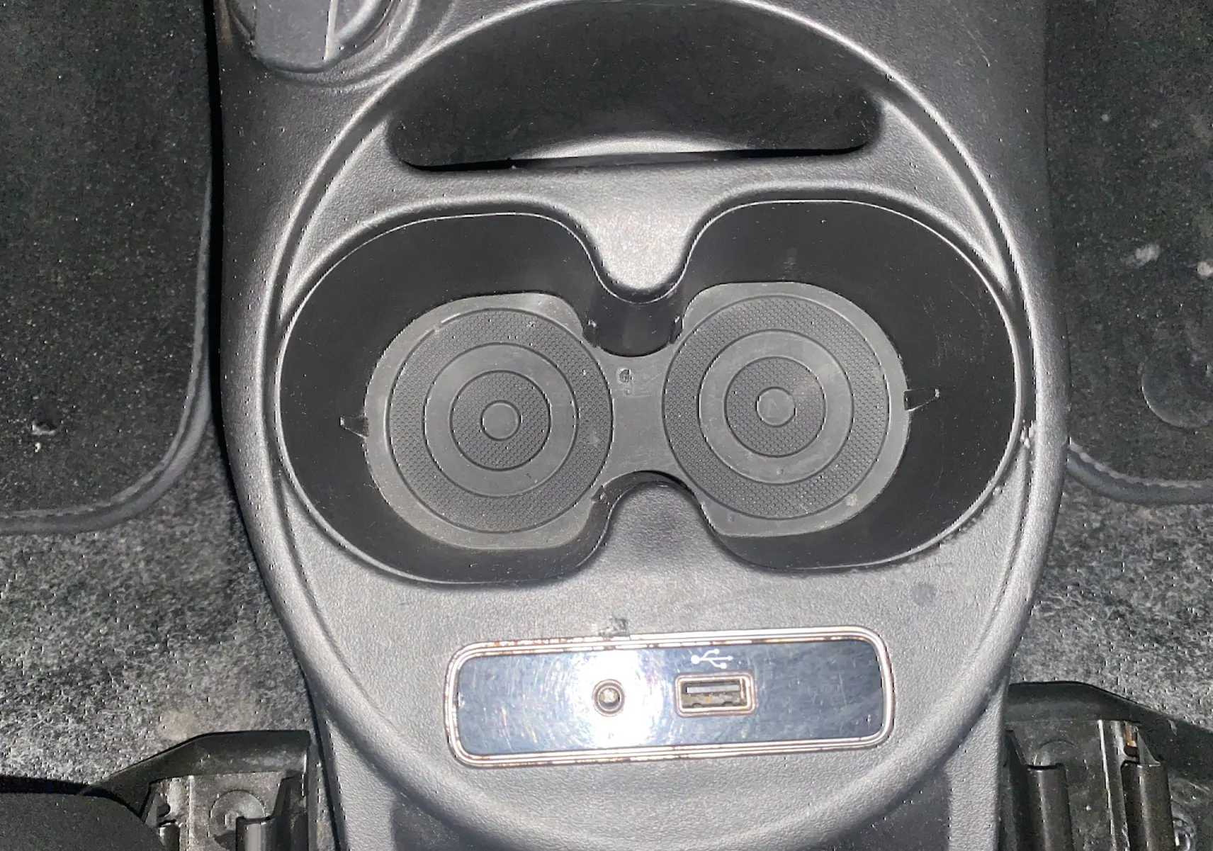 Gros plan sur les porte-gobelets et prise USB au centre de la console d'une ABARTH 595 noire de 2018.