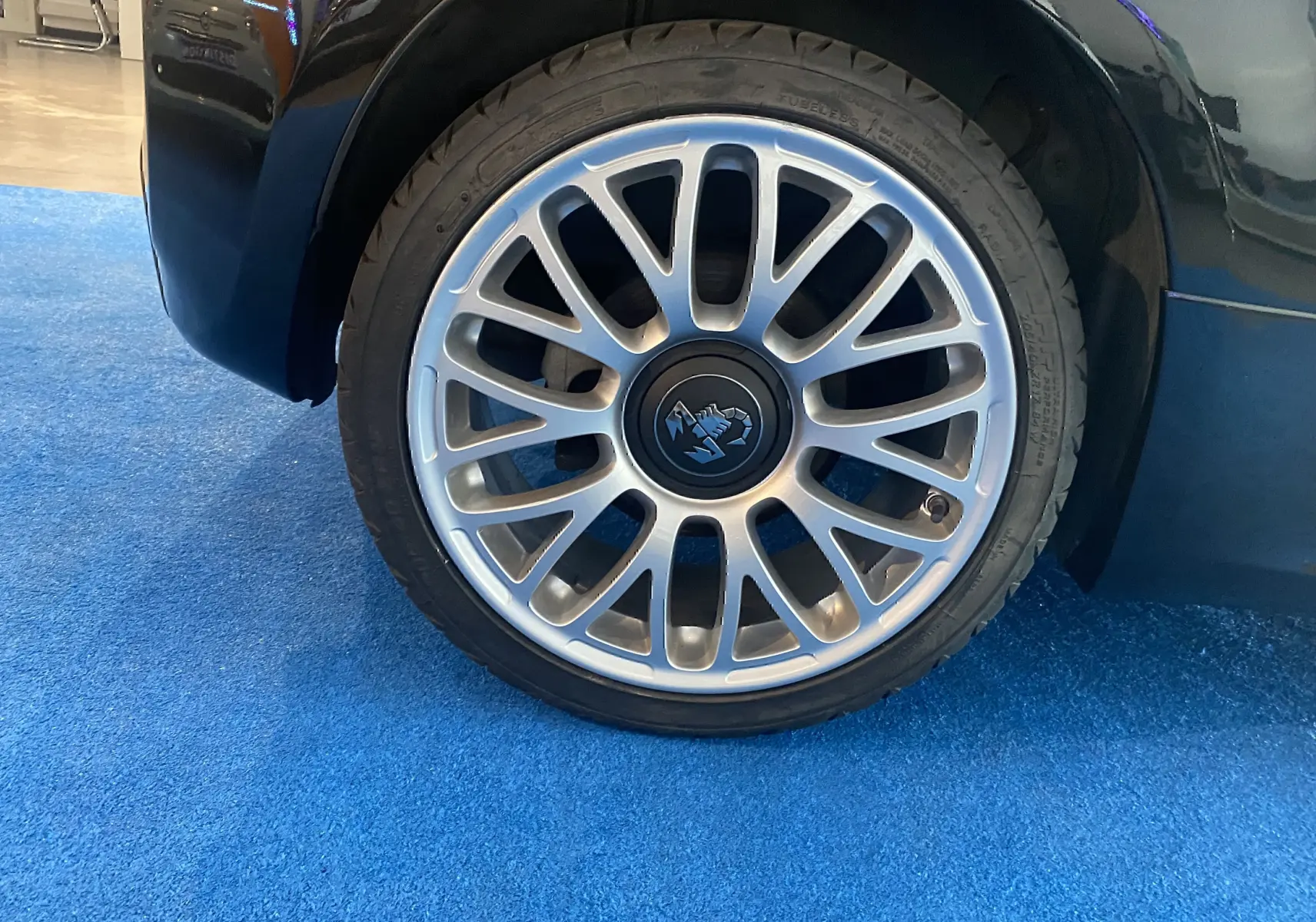 Gros plan sur la jante alu argentée avec logo Abarth au centre, côté arrière droit d'une ABARTH 595 noire.