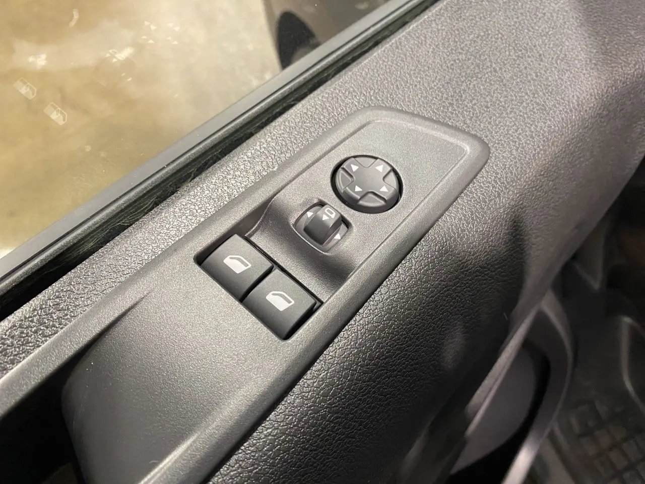 Gros plan sur les commandes de réglage des rétroviseurs et vitres côté conducteur du Citroën Jumpy Fourgon gris platinium 2024.