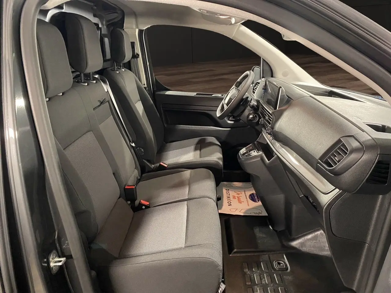 Intérieur du Citroën Jumpy Fourgon 2024 en gris platinium, vue côté gauche sur les sièges avant et tableau de bord.